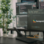 Imagem de destaque para o artigo 'Como configurar múltiplos monitores no Linux'. A imagem mostra uma estação de trabalho com múltiplos monitores exibindo códigos de programação, simbolizando o uso de múltiplas telas para aumentar a produtividade.