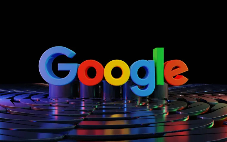 Logotipo 3D do Google em cores vibrantes sobre uma superfície reflexiva, com fundo preto.