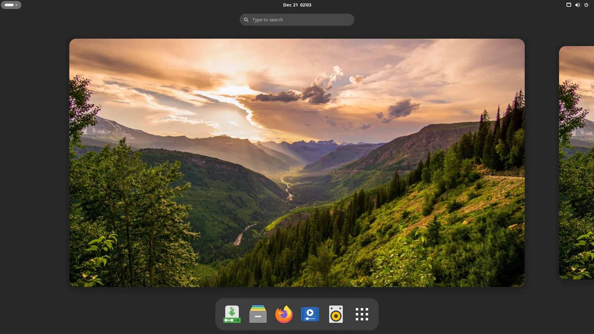 Captura de tela do ambiente de desktop GNOME no Solus 4.6, com um papel de parede de montanhas ao entardecer e uma barra inferior com ícones de aplicativos como Firefox e Celluloid.