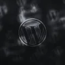 Logotipo do WordPress em tons de preto e cinza, sobre um fundo escuro com várias sombras do mesmo símbolo