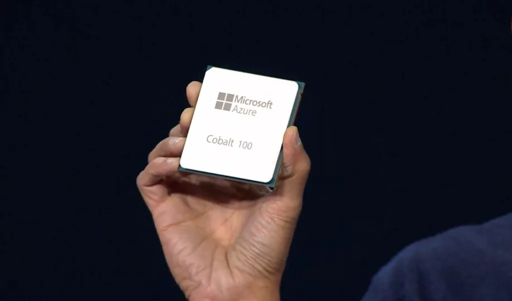 Processador Microsoft Azure Cobalt 100 sendo segurado por uma mão, exibindo o nome e o logotipo da Microsoft na parte frontal do chip.