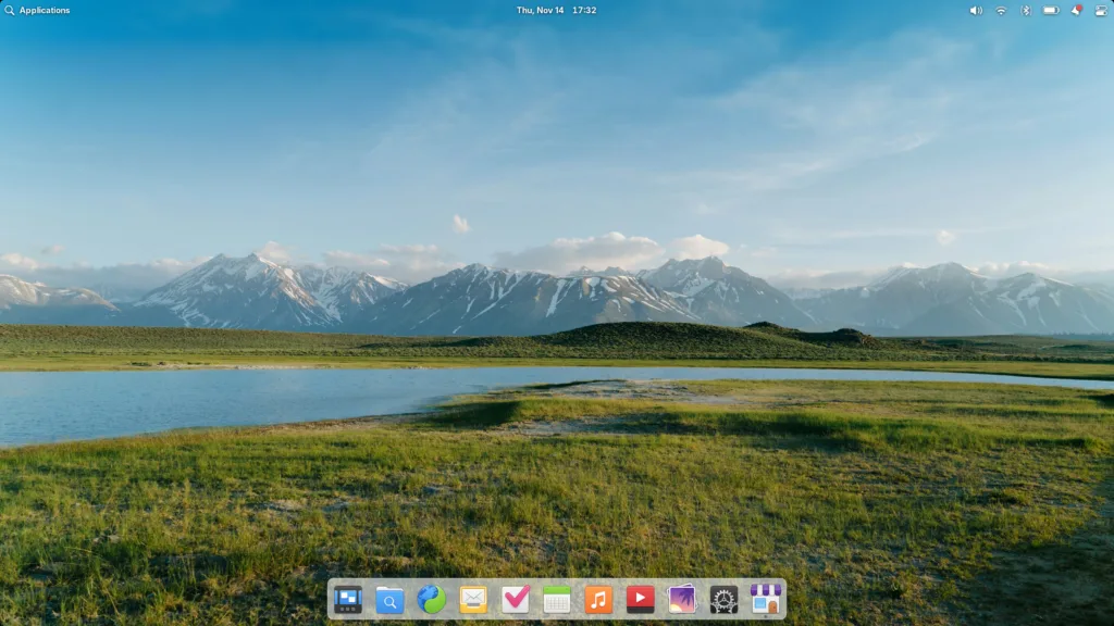 Tela inicial do elementary OS 8 com papel de parede de paisagem e dock exibindo ícones de aplicativos.