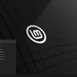Tela inicial do Linux Mint 22.1 com tema escuro, logotipo centralizado, menu de aplicativos aberto no canto inferior esquerdo, mostrando categorias como LibreOffice, Internet e Administração.