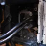 Close-up de módulos de memória RAM DDR4 HyperX instalados em um computador, com detalhes do sistema de refrigeração líquida e componentes internos, representando tecnologia de hardware de alto desempenho.