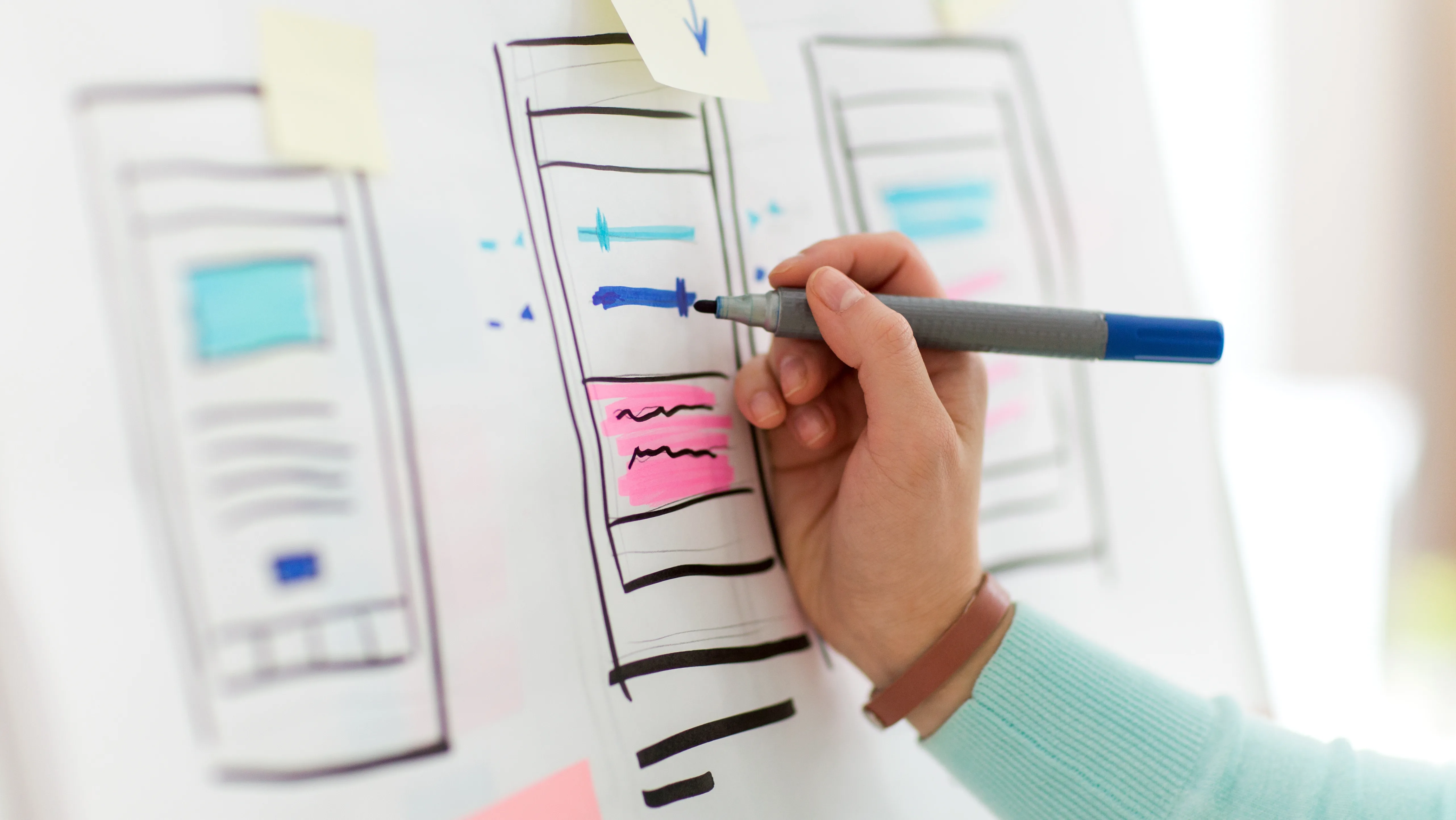 a hand holding a marker over a whiteboard