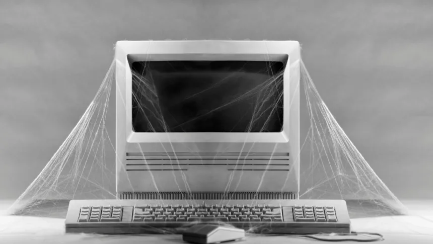 Computador obsoleto coberto por teias de aranha representando hardware RISC-V antigo sem suporte no Ubuntu RISC-V RVA23