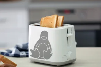 Torradeira branca com o mascote Tux do Linux, simbolizando o conceito de Linux em torradeira