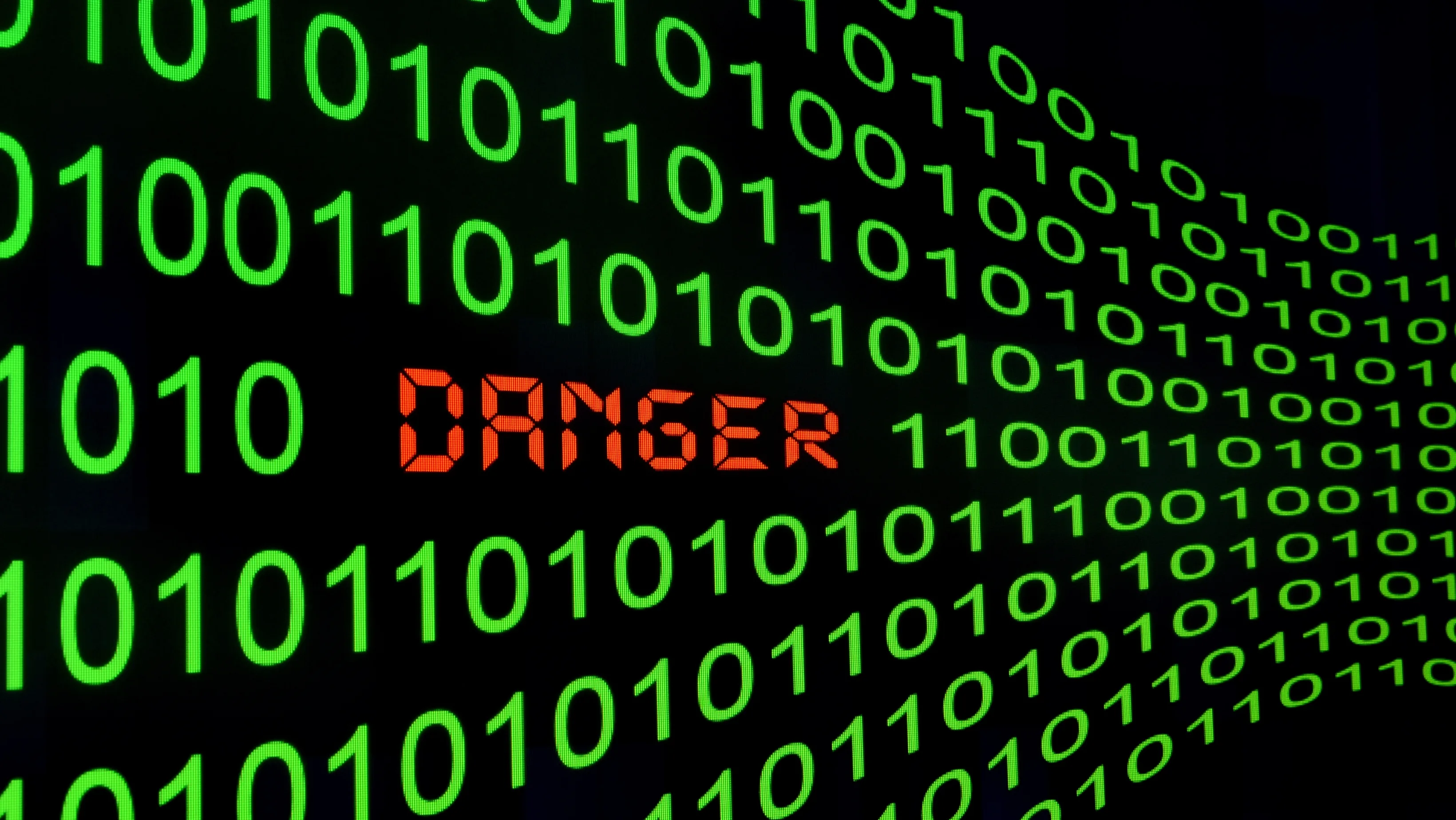 Sequência de zeros e uns em verde com a palavra ‘DANGER’ em vermelho no centro, ilustrando o botão de autodestruição Linux e o risco de comandos maliciosos.