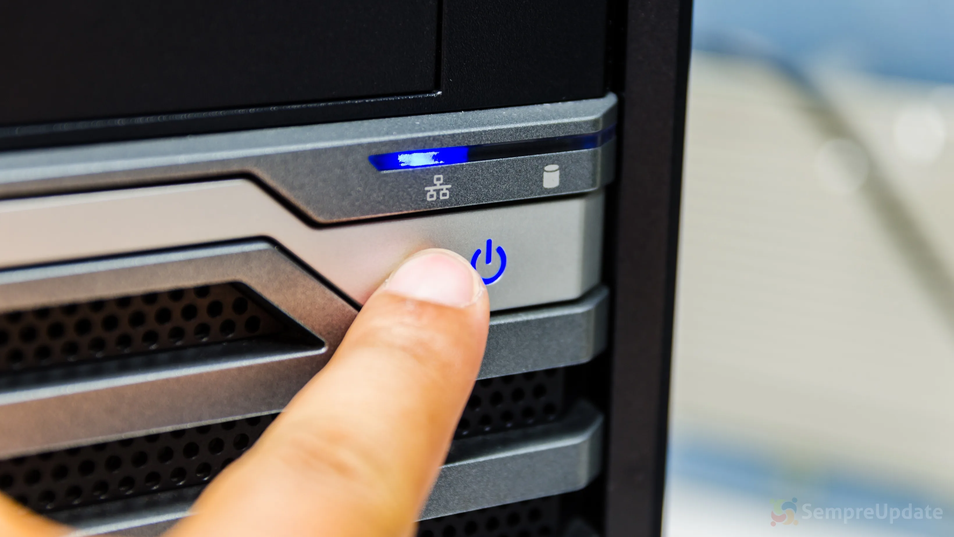 Botão de energia sendo pressionado para desligar ou hibernar Linux em um desktop moderno