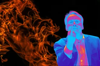 Homem de óculos em efeito térmico, de terno, faz gesto do dedo do meio diante de chamas em fundo preto