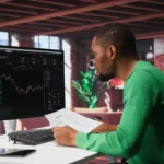 american man using pc purchase sell stocks